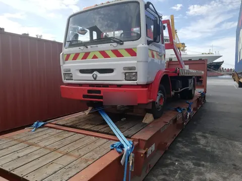 Camion de dépannage Renault arrimé sur un flat rack devant un navire avant expédition — IFTL