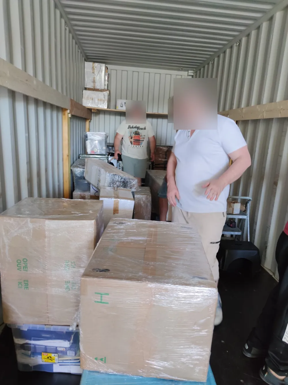 Cartons d'effets personnels calés sur fardage en bois dans le conteneur de déménagement — IFTL