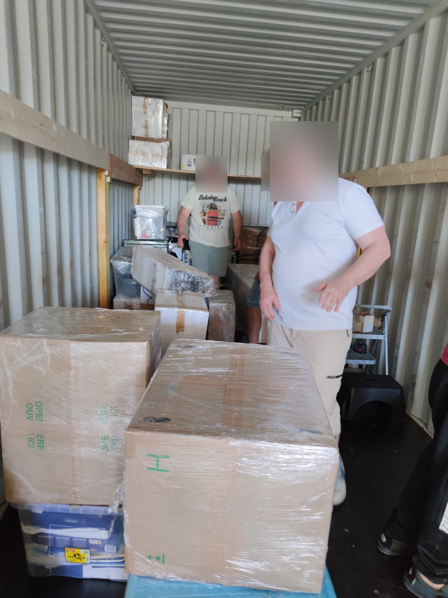 Cartons d'effets personnels calés sur fardage en bois dans le conteneur de déménagement — IFTL