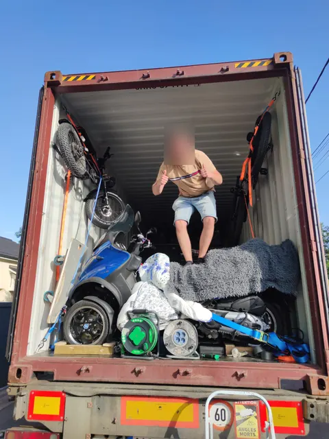 Scooters et vélos arrimés par sangles à cliquet dans le conteneur avant le transport maritime — IFTL