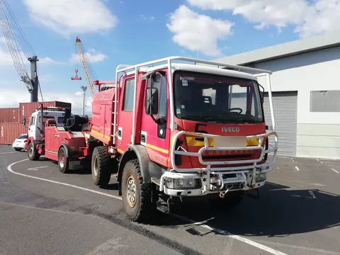Camion de pompiers IVECO remorqué par une dépanneuse sur le quai du port — IFTL