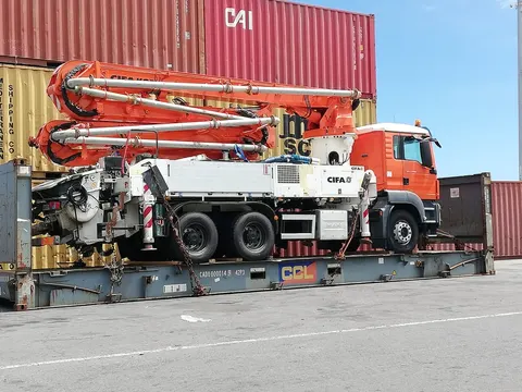 Pompe à béton CIFA sur camion MAN arrimée sur un flat rack, transport hors gabarit — IFTL