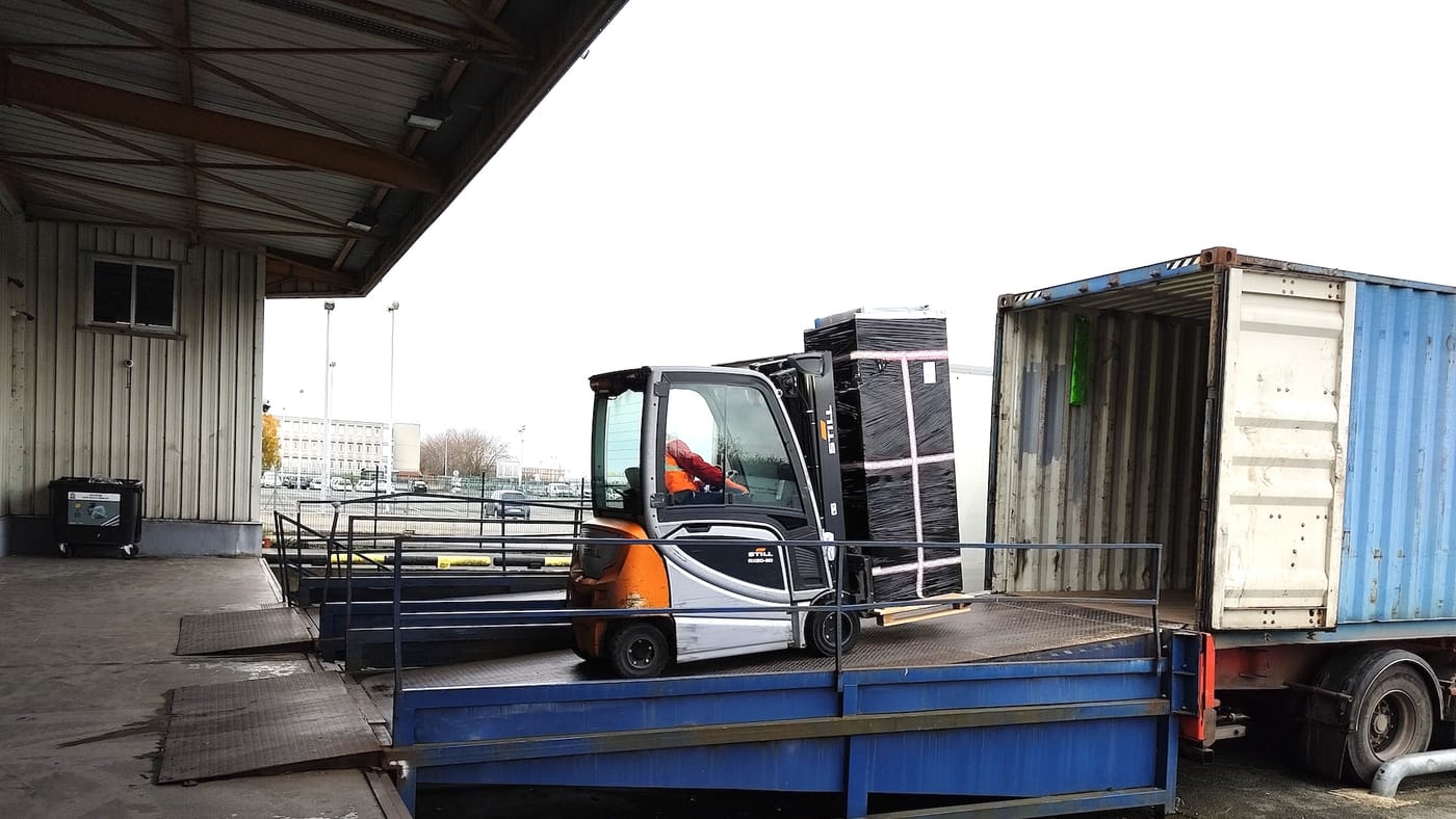 Palettes et cartons sanglés dans un conteneur maritime