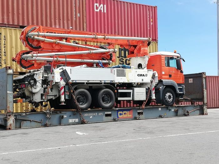Pompe à béton chargée sur flat rack, expédition hors gabarit organisée par IFTL